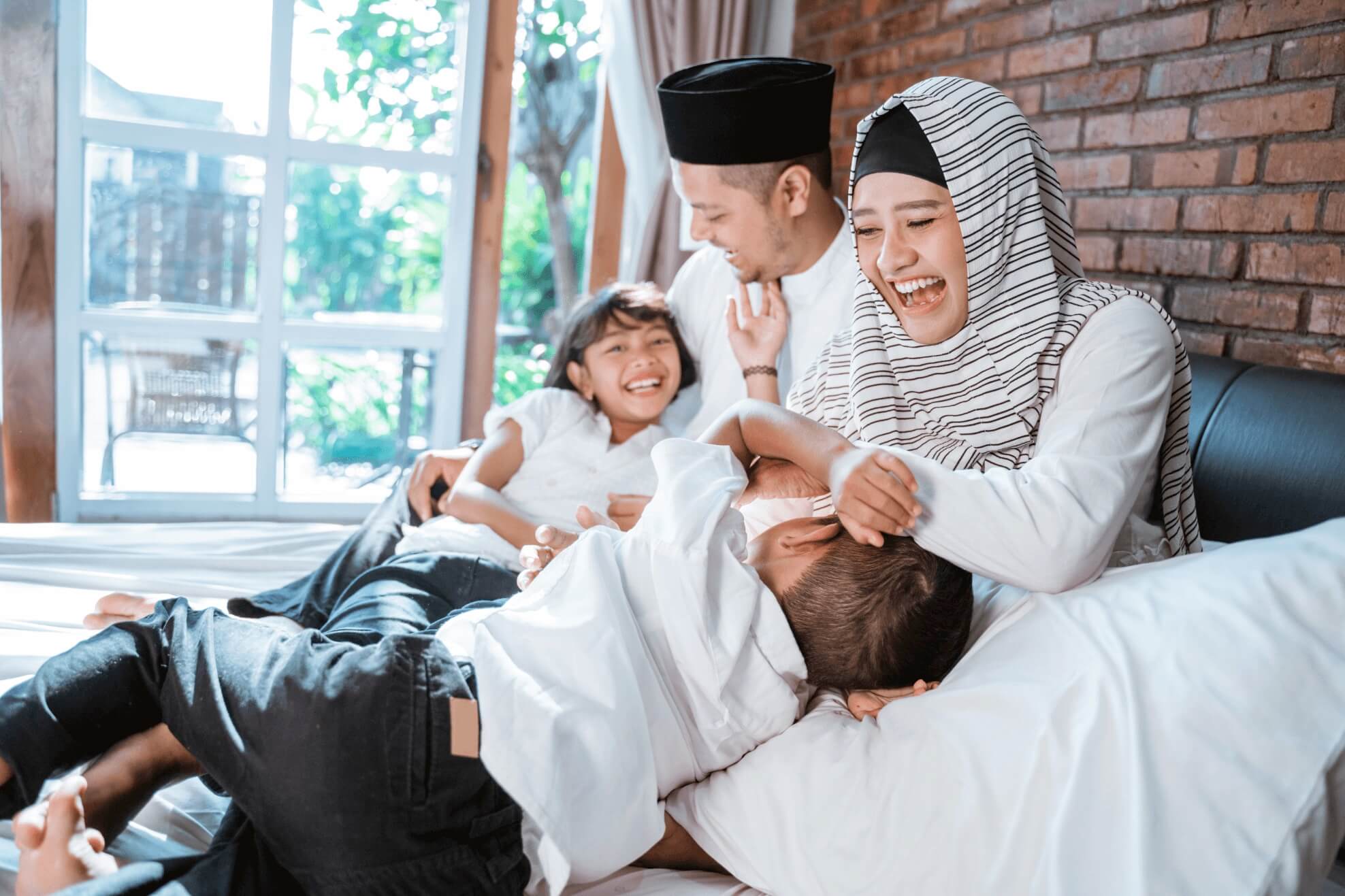 Muslim family playing with their babies on the sofa 
