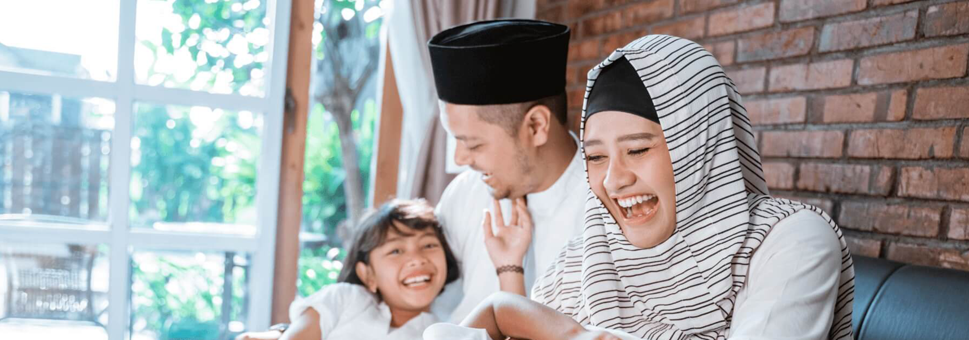 Muslim family playing with their babies on the sofa 